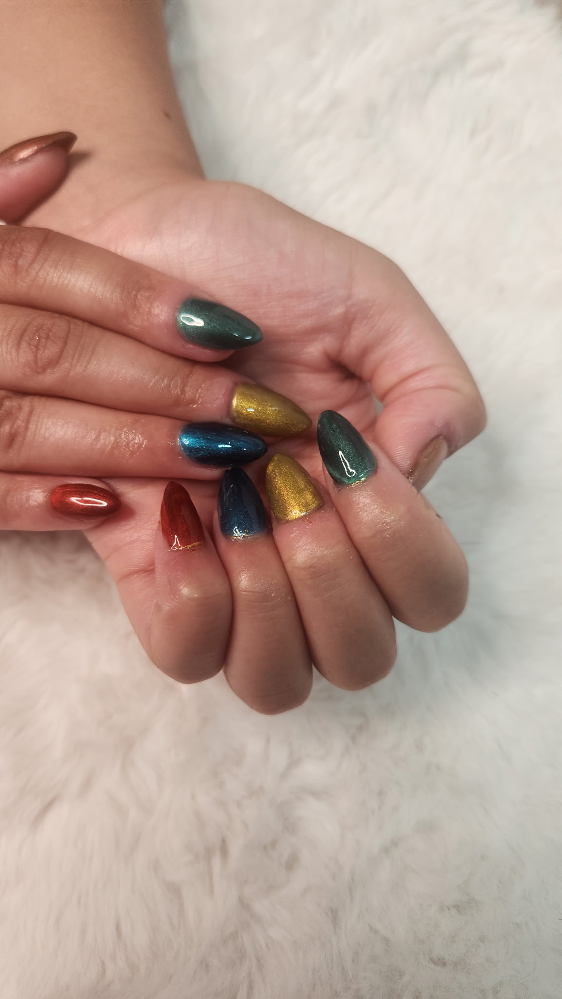 Metallic cat-eye gel manicure in green, gold and red almond shape